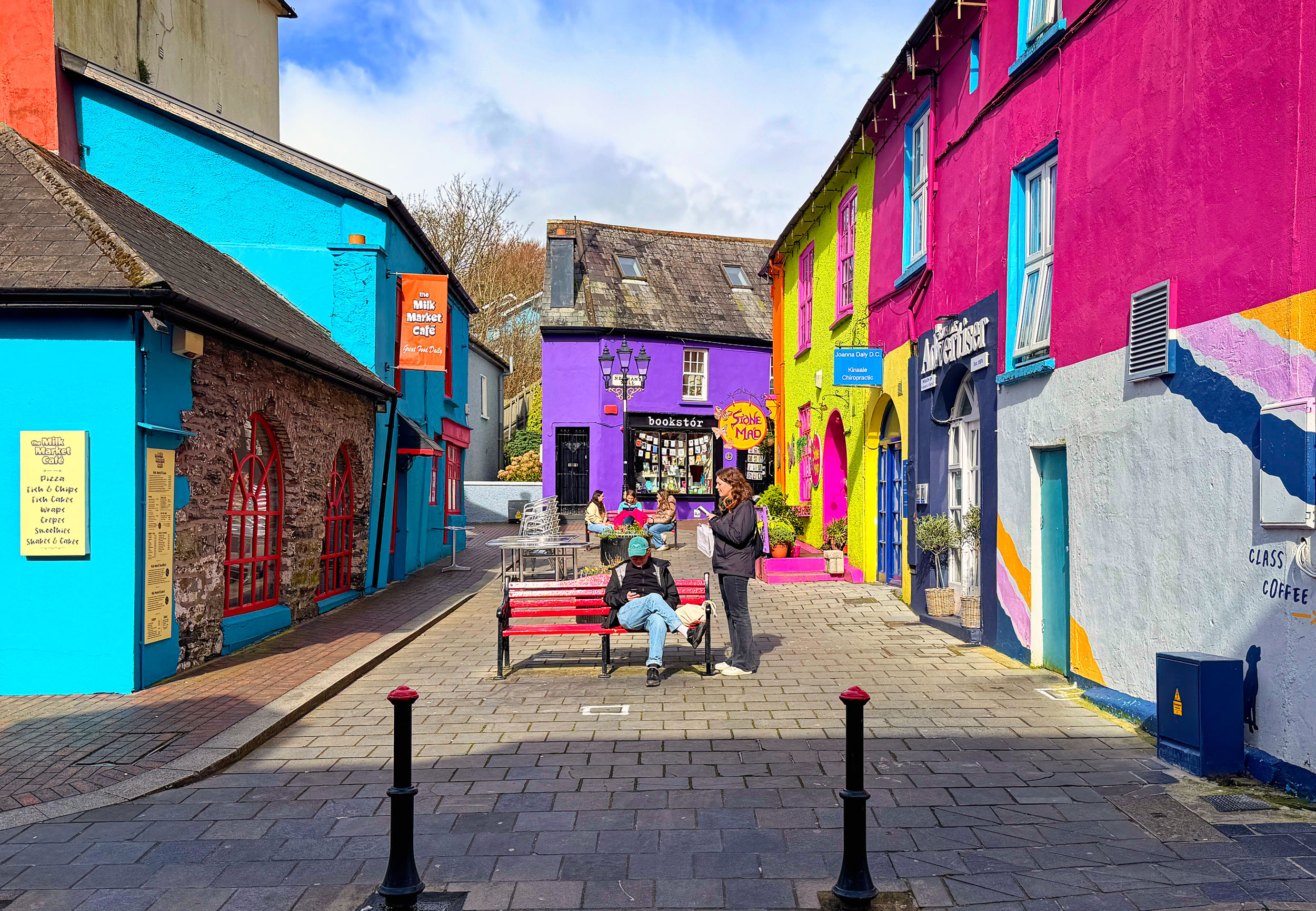 One of the most colorful towns in Ireland, shoppers soak in some early spring sun at Newman's Mall, Kinsale, County Cork